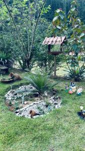 a garden with two animals laying in the grass at Chácara nosso pedacinho do céu in Domingos Martins