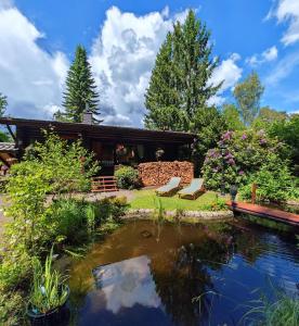 a house with a pond in the yard at Das Heide Blockhaus in Handeloh