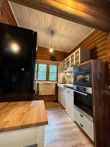 a kitchen with a black refrigerator and a stove at Das Heide Blockhaus in Handeloh