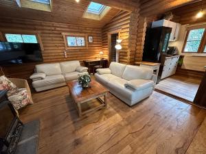 a living room with a white couch and a table at Das Heide Blockhaus in Handeloh +21 photos