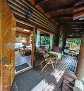 a wooden deck with a table and chairs on it at Das Heide Blockhaus in Handeloh