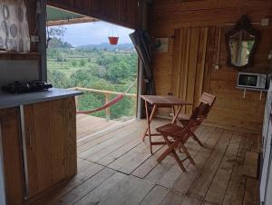 a room with a table and a chair on a wooden floor at Cabana do Gipsy in Ponte da Barca