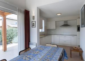 a kitchen with a table with a blue tablecloth on it at Villa les Mazes in Vallon-Pont-dʼArc