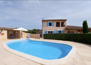 a swimming pool in front of a villa at Villa les Mazes in Vallon-Pont-dʼArc