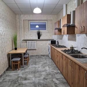a kitchen with a sink and a table in it at Hostel Włocławek in Włocławek