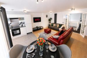 a living room with a table and a couch at Spacious, Modern and stylish three bedroom home , perfect for work , leisure and contractors ,5 mins walk to Newcastle city Center, Newcastle stadium and Newcastle University, Free parking Fast WiFi, conveniently located both short stay and long stays in Newcastle upon Tyne