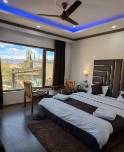 a bedroom with a large bed and a large window at Hotel La Park, Leh in Leh