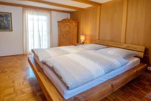 a large wooden bed in a room with a window at Fischerhaus am Moosbach mit Sauna in Mietenkam +12 photos