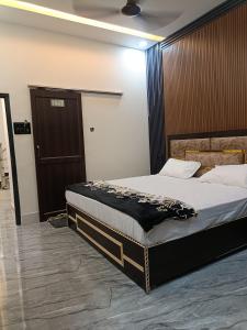 a bedroom with a bed and a wooden door at Gita Raman Palace in Ayodhya