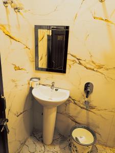 a bathroom with a sink and a mirror and a toilet at Gita Raman Palace in Ayodhya