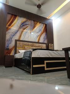 a bedroom with a large bed with a large painting on the wall at Gita Raman Palace in Ayodhya