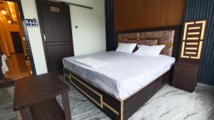 a bedroom with a large bed with a wooden headboard at Gita Raman Palace in Ayodhya +8 photos