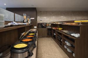a buffet line with many different types of food at Athus Brasilia Hotel by Bsb Inn in Brasília