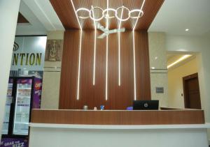 a lobby with a desk with a laptop on it at SNR GRAND in Narasaraopet