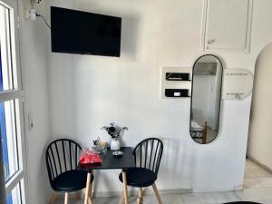 a dining room with a table and chairs and a mirror at Studios Zafiri in Naxos Chora