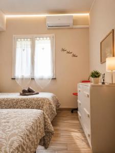 a bedroom with two beds and a dresser and a window at Marino Apartments in Levanto