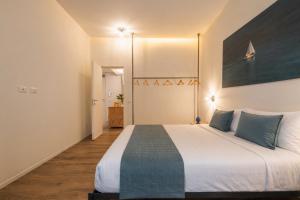 a bedroom with a large white bed with blue pillows at Palazzo Lucatelli Suite - Centro in Trapani