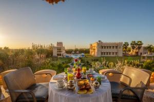 a table with food on it with a view of a city at Atlas Castle Marrakech in Marrakesh