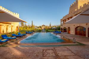 a swimming pool with blue chairs and a building at Atlas Castle Marrakech in Marrakesh +41 photos