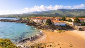 an aerial view of a beach with houses and the ocean at Apto Llanes Bajo con terraza - Casa Juanín in Llanes