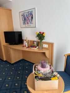 a hotel room with a desk and a table with a chair at Hotel Am Schlosspark , Wiesbaden in Wiesbaden