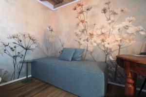 a room with a blue couch with flowers on the wall at Villa Valdobbiadene Pool Spa in Valdobbiadene
