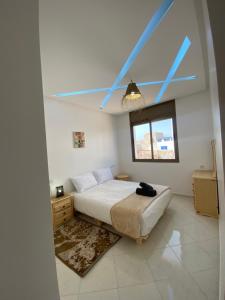 a bedroom with a bed and a window at Appartement Tourma in Agadir
