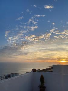 a view of the ocean at sunset from a rooftop at Appartement Tourma in Agadir