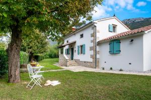 a white house with a table and a tree at Villa Rocco in Kozljak