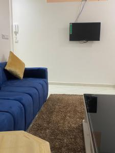 a blue couch in a living room with a tv at Appartement Tourma in Agadir