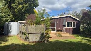 a small house with a fence in front of it at Thyme On The Terrace in Te Anau