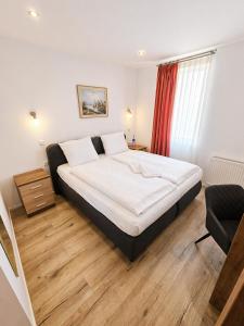 a bedroom with a large bed and a chair at Hotel Post Nürtingen in Nürtingen
