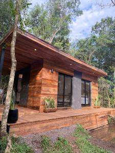 a house with a wooden deck in the woods at Refugio El Benja in Villa Salto Encantado