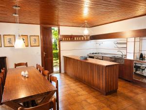 a kitchen with a wooden table and a dining room at Villa by the Sea and shared Pool in Lignano Sabbiadoro