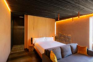 a bedroom with a bed and a couch at Belle Torre Mayorazgo Boutique Hotel in Villatoro