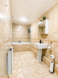 a bathroom with a sink and a bath tub at Spacious, Modern and stylish three bedroom home , perfect for work , leisure and contractors ,5 mins walk to Newcastle city Center, Newcastle stadium and Newcastle University, Free parking Fast WiFi, conveniently located both short stay and long stays in Newcastle upon Tyne