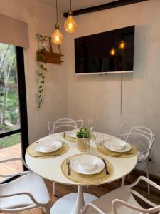 a white table with chairs and plates on it at Refugio El Benja in Villa Salto Encantado