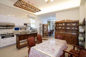una cucina con tavolo e sedie in una stanza di Rose Rider Guesthouse a Città di Taitung