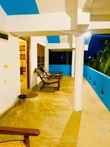a room with a table and a bench on a floor at Paradise Bay Hotel in Arugam Bay