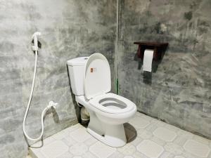 a bathroom with a toilet with a shower in it at Paradise Bay Hotel in Arugam Bay