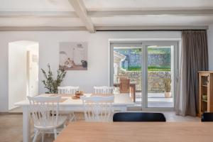 a dining room with a white table and chairs at Villa Rocco in Kozljak