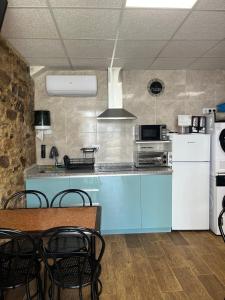 a kitchen with a blue counter and a white refrigerator at Albergue Freixo in Palas de Rei