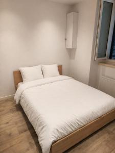 a large white bed in a room with a window at T2 TARBES Centre Ville in Tarbes