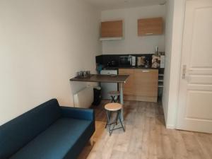 a living room with a couch and a table and a kitchen at T2 TARBES Centre Ville in Tarbes