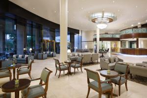 eine Hotellobby mit Tischen und Stühlen in der Unterkunft Crowne Plaza Riyadh Palace by IHG in Riad