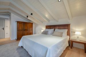 a bedroom with a white bed with a wooden headboard at Villa Rocco in Kozljak +39 photos