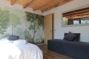 a bedroom with two beds and a couch at Villa Valdobbiadene Pool Spa in Valdobbiadene +35 photos