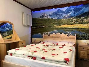 ザコパネにあるChatka U Hazy - Regionalne Pokoje Zakopaneのベッドルーム1室(壁に絵画が描かれたベッド1台付)