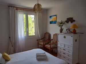 a bedroom with a bed and a dresser and a window at Villa Do Sol Chambre d'Hôtes "Arbousiers" in Arcachon