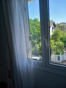 a window with a view of a yard at Villa Do Sol Chambre d'Hôtes "Arbousiers" in Arcachon